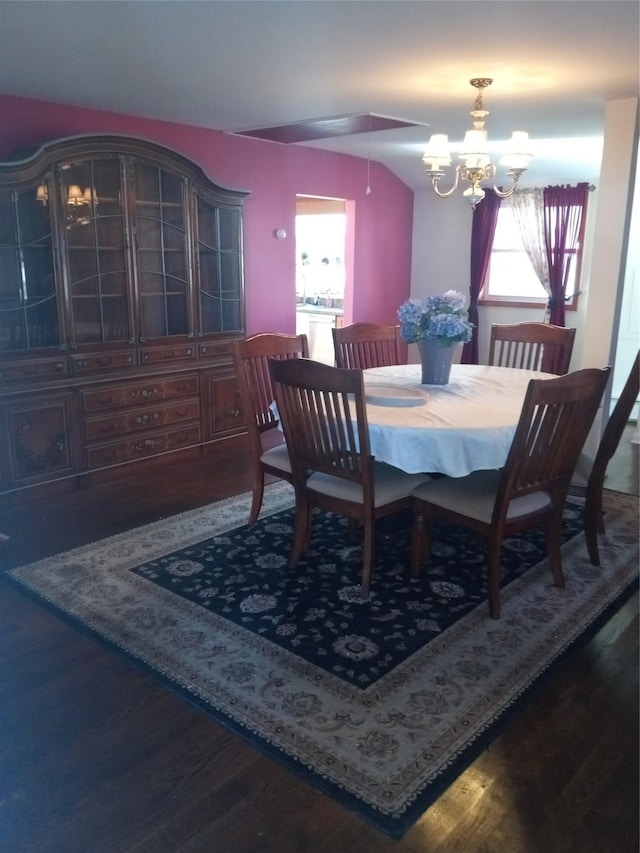 dining room featuring a chandelier, plenty of natural light, lofted ceiling, and wood finished floors