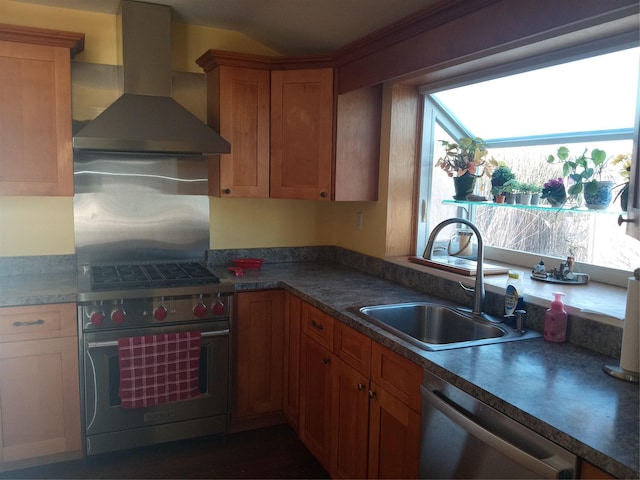 kitchen featuring brown cabinetry, lofted ceiling, a sink, appliances with stainless steel finishes, and wall chimney exhaust hood