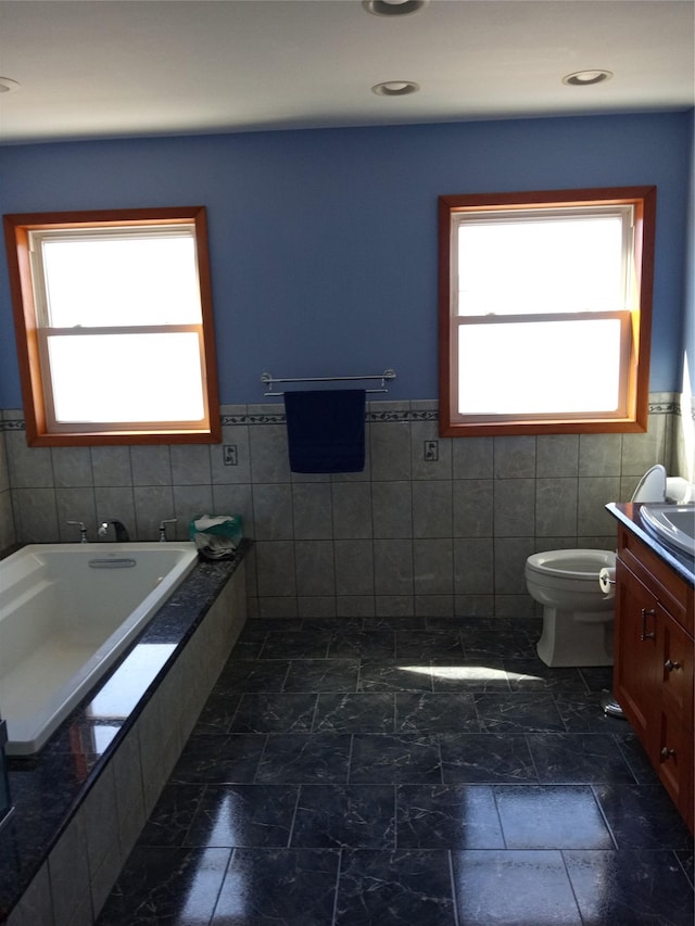 2706 Peconic Ave, Seaford, NY 11783 - bathroom featuring toilet, vanity, plenty of natural light, and a relaxing tiled tub