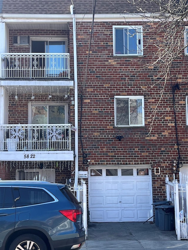 5822 Van Cleef St, Corona, NY 11368 - view of side of property featuring brick siding, an attached garage, driveway, and roof with shingles