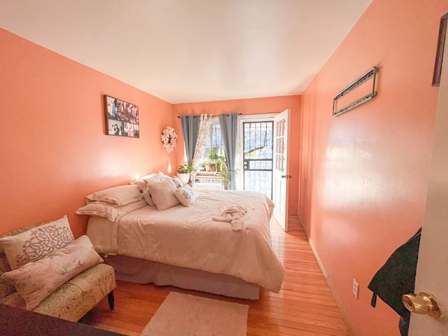 5822 Van Cleef St, Corona, NY 11368 - bedroom featuring access to exterior, light wood-type flooring, and baseboards