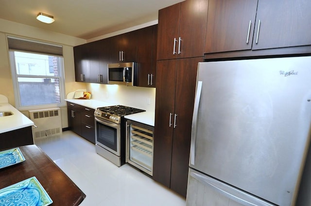 kitchen featuring dark brown cabinets, appliances with stainless steel finishes, radiator heating unit, and light countertops