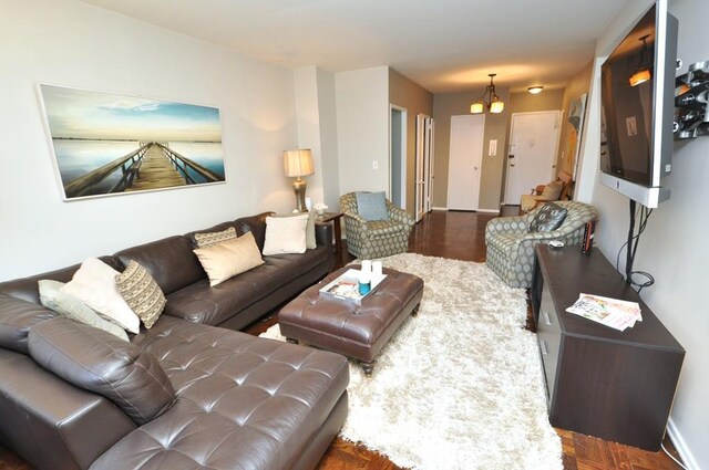 living area with an inviting chandelier, wood finished floors, and baseboards