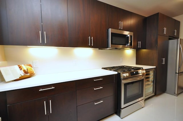 kitchen with light countertops, wine cooler, appliances with stainless steel finishes, and dark brown cabinetry