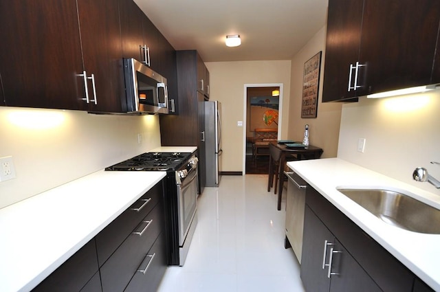 kitchen with a sink, dark brown cabinets, light countertops, stainless steel appliances, and modern cabinets