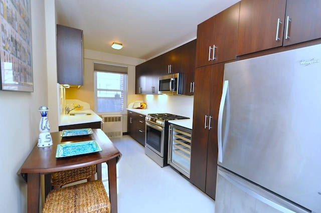 kitchen with radiator heating unit, a sink, stainless steel appliances, light countertops, and dark brown cabinets