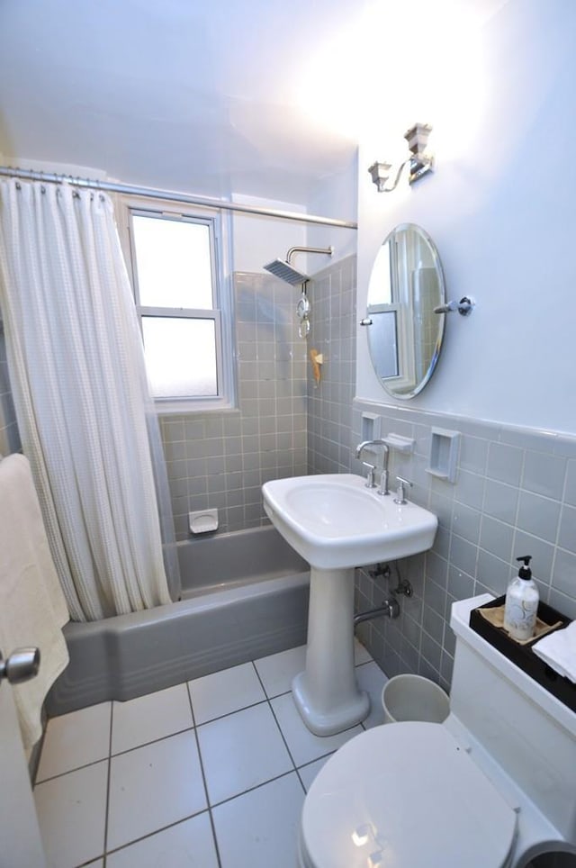 full bathroom featuring toilet, shower / tub combo with curtain, tile walls, wainscoting, and tile patterned flooring