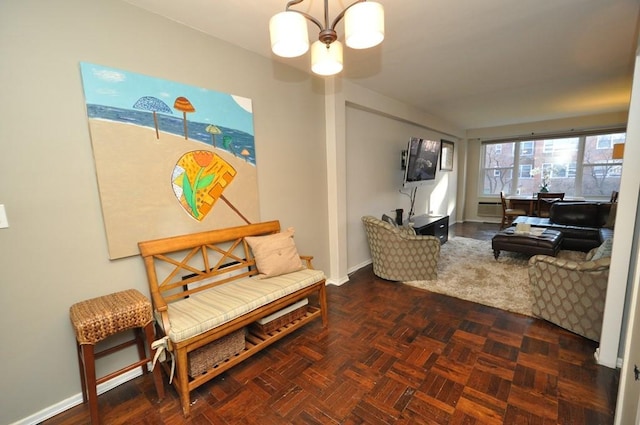 living area with baseboards and a chandelier