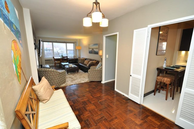 living area featuring baseboards and a notable chandelier