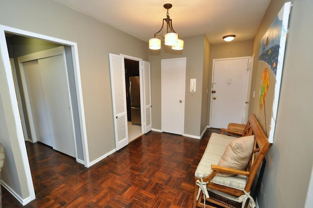 hallway featuring an inviting chandelier and baseboards