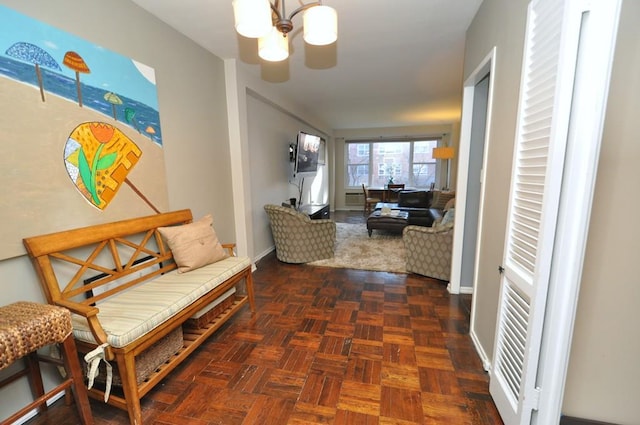 hallway featuring a notable chandelier and baseboards