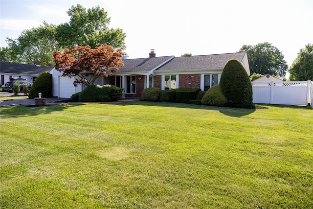 ranch-style home with fence, a chimney, a front lawn, a garage, and brick siding