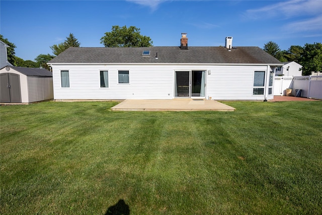 rear view of house with an outbuilding, a shed, a lawn, and fence