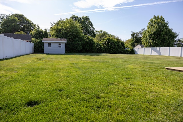 view of yard featuring an outbuilding, a storage shed, and a fenced backyard