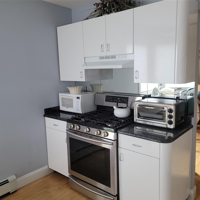 kitchen featuring under cabinet range hood, white cabinets, a baseboard radiator, gas range, and white microwave