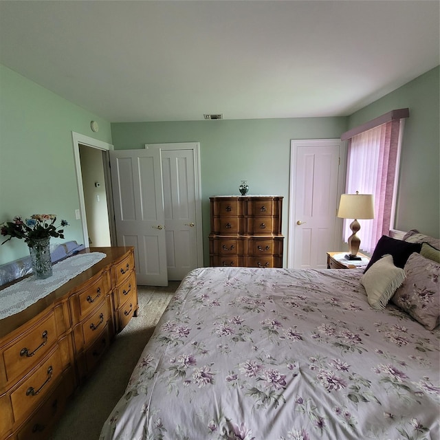 carpeted bedroom featuring visible vents