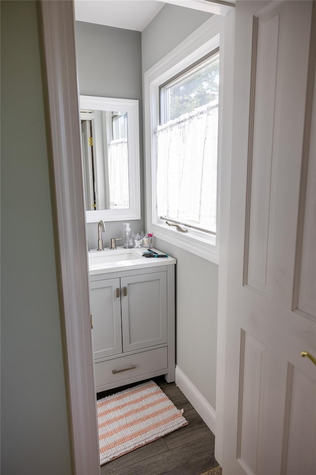 bathroom featuring vanity, baseboards, and wood finished floors