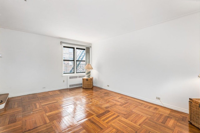 unfurnished room featuring radiator heating unit and baseboards