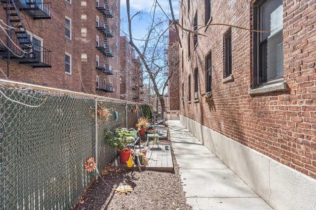 view of side of home with fence and brick siding