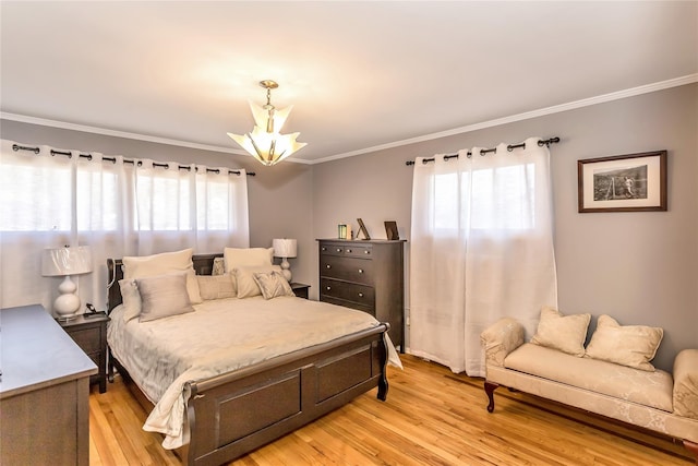 bedroom featuring an inviting chandelier, light wood-style flooring, and crown molding