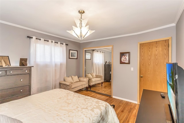 bedroom featuring crown molding, light wood-style floors, baseboards, and a closet