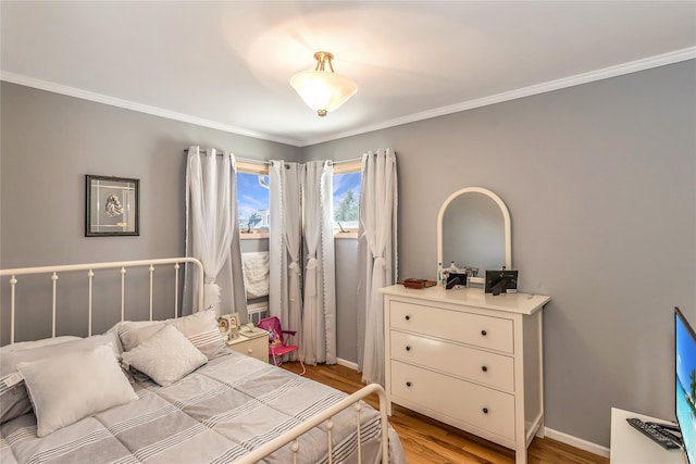 bedroom with light wood finished floors, baseboards, and ornamental molding