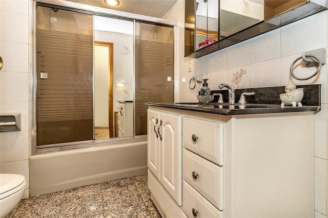 bathroom featuring tasteful backsplash, toilet, tile walls, and vanity