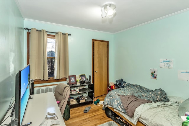 bedroom featuring wood finished floors and ornamental molding