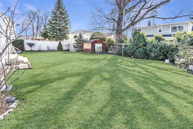 view of yard with a fenced backyard, a storage shed, and an outdoor structure