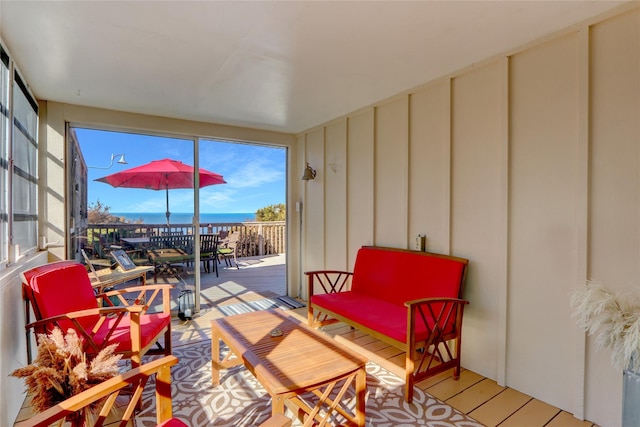 sunroom featuring a water view