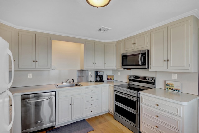 kitchen with visible vents, light wood finished floors, a sink, light countertops, and appliances with stainless steel finishes
