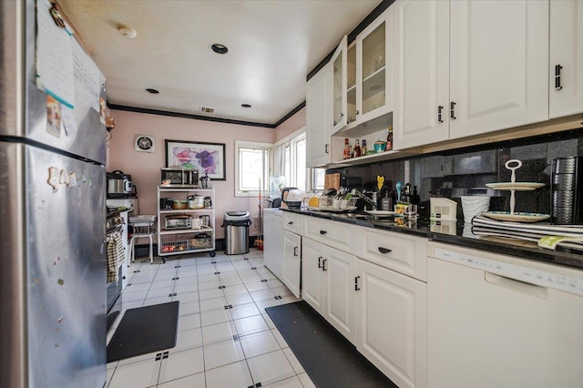 kitchen with white dishwasher, freestanding refrigerator, glass insert cabinets, white cabinetry, and dark countertops