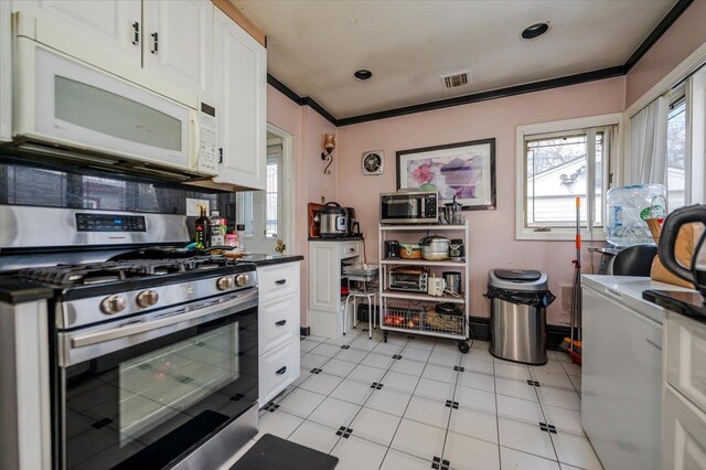 kitchen with visible vents, dark countertops, appliances with stainless steel finishes, and crown molding