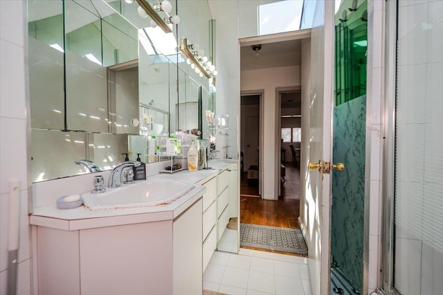 full bathroom featuring tile patterned flooring, double vanity, and a sink