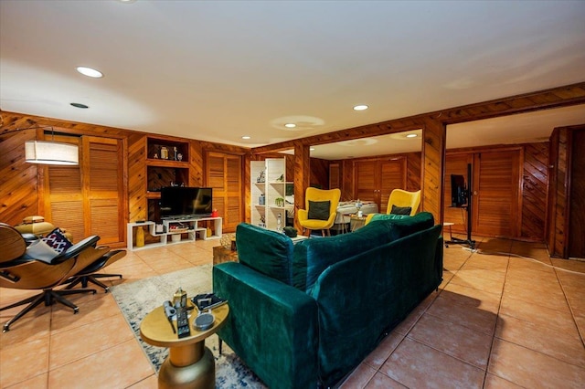 living room featuring light tile patterned floors, wooden walls, and recessed lighting