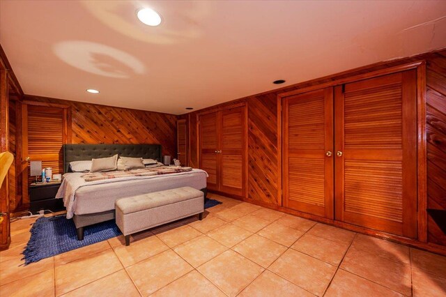 bedroom featuring wooden walls, light tile patterned flooring, and recessed lighting