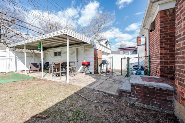 exterior space featuring a patio, a gate, fence, and brick siding