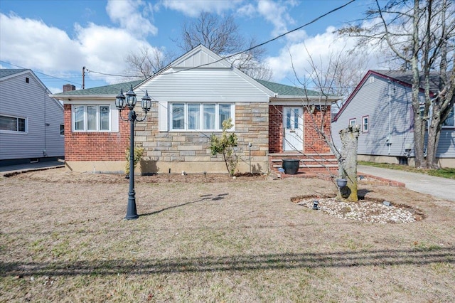 bungalow featuring brick siding and stone siding