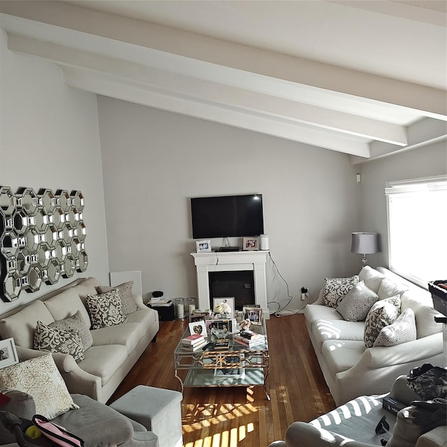 living area featuring a fireplace, lofted ceiling with beams, and wood finished floors