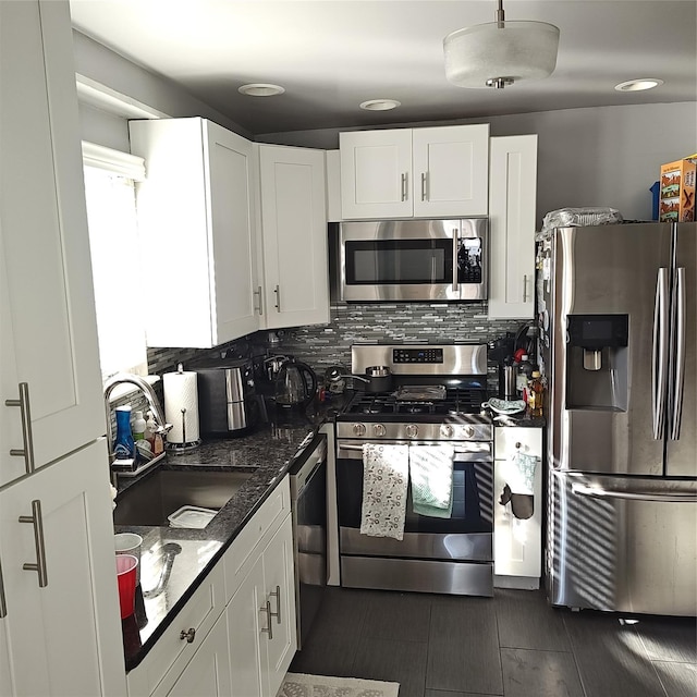 kitchen featuring decorative backsplash, appliances with stainless steel finishes, white cabinetry, and a sink