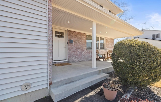 view of exterior entry featuring covered porch