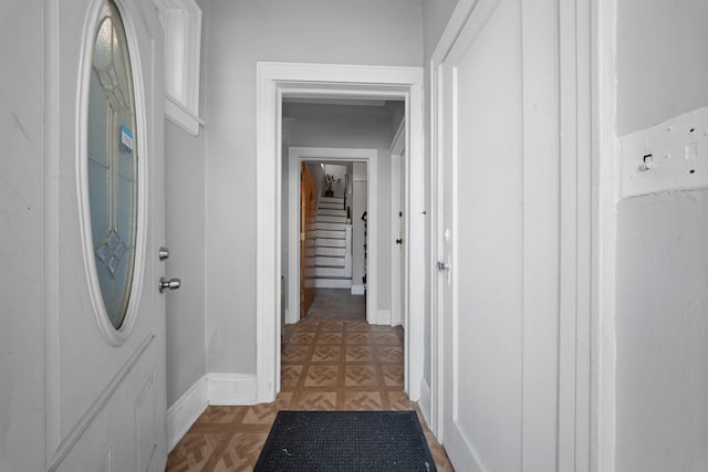 hall featuring stairway and baseboards