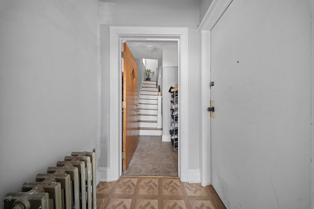 hallway featuring stairway and radiator heating unit