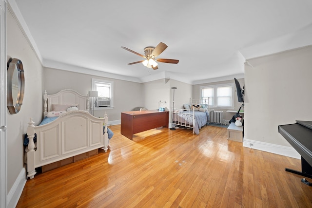 bedroom featuring ceiling fan, radiator, baseboards, and light wood-style floors