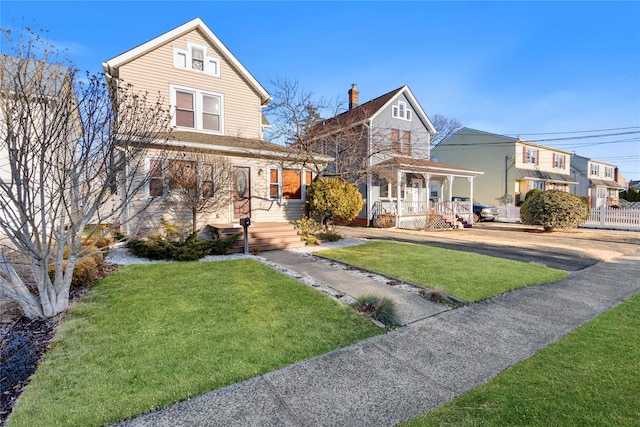 view of front facade with a front lawn and fence