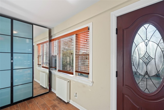 interior space with radiator heating unit, baseboards, and wood finish floors