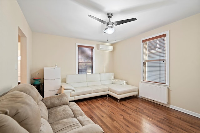 living room featuring an AC wall unit, radiator, wood finished floors, and a wealth of natural light