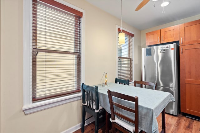 dining room with baseboards, wood finished floors, and a ceiling fan