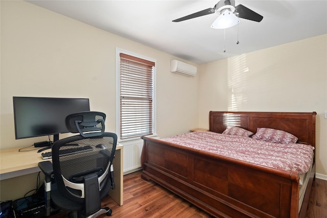 bedroom featuring ceiling fan, an AC wall unit, and wood finished floors