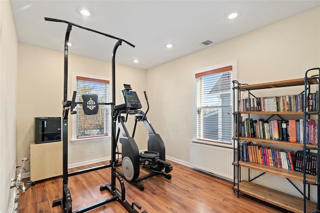 exercise room with recessed lighting, visible vents, baseboards, and wood finished floors